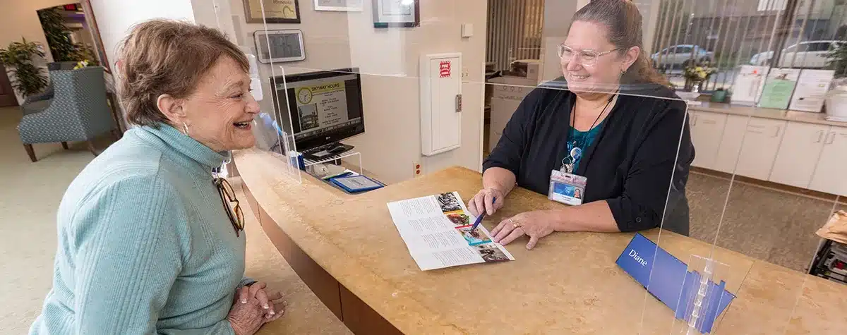 Charter House Staff Showing Resident Brochure