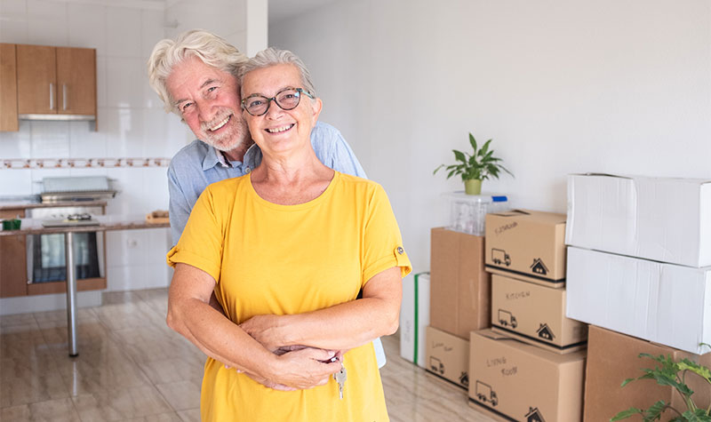 Senior Couple Smiling Moving In To New Home