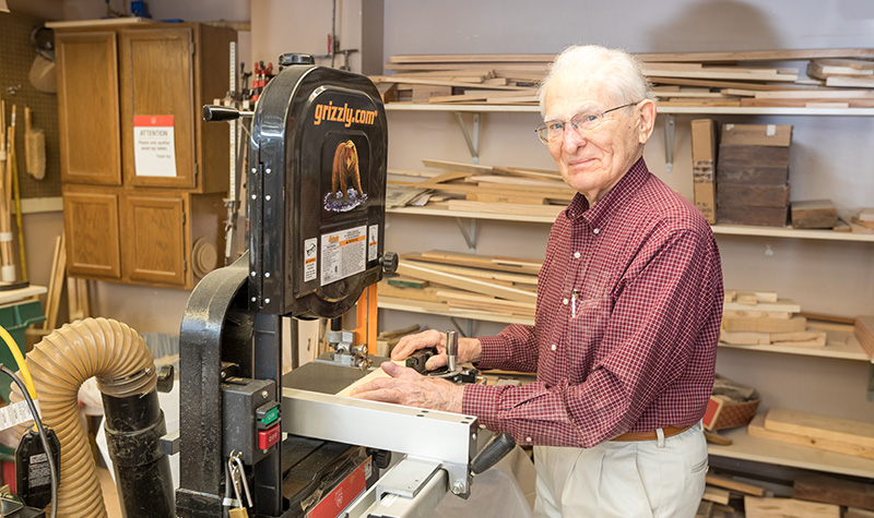 Senior Person Standing At Band Saw