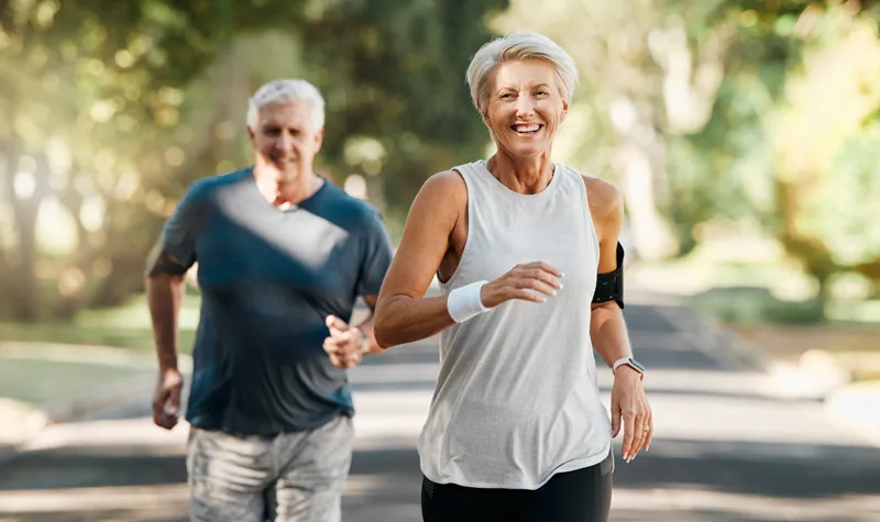 Healthy Elderly Couple Jogging Amongs Trees