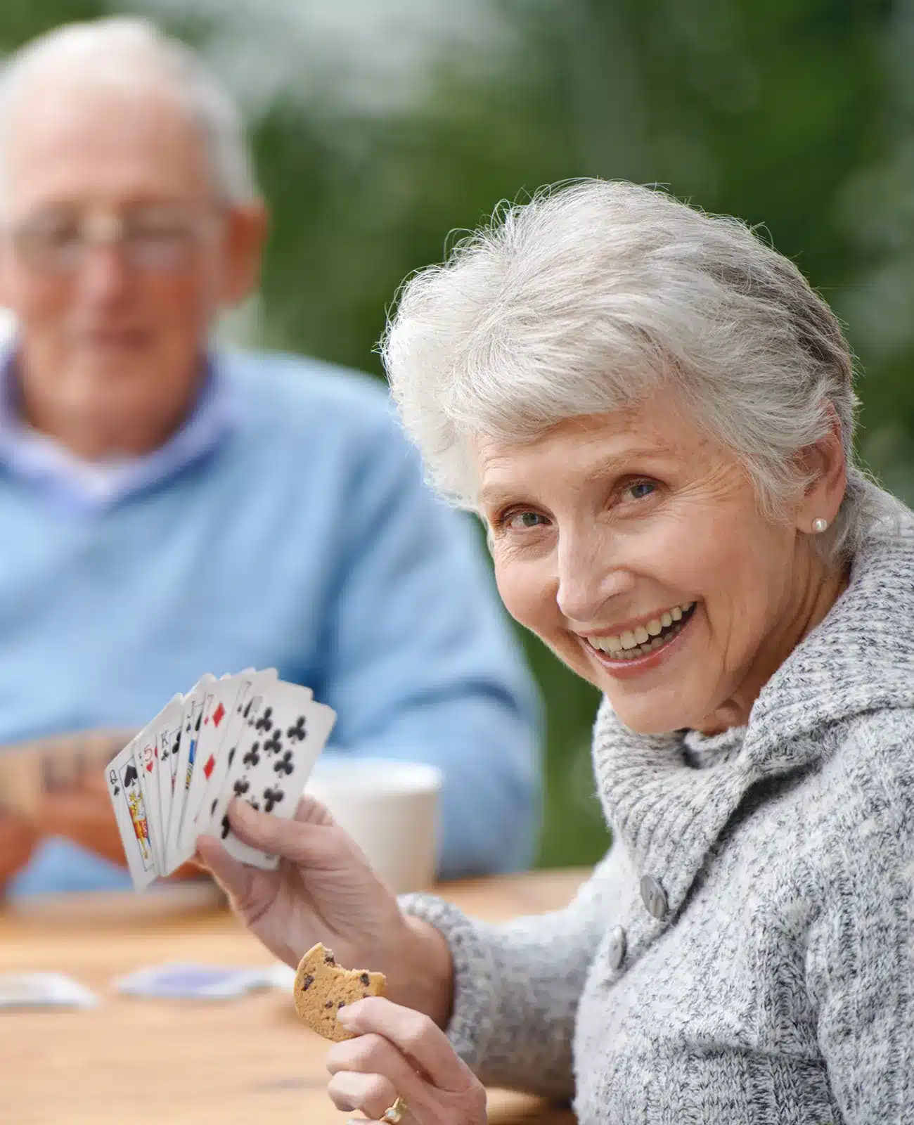 Elderly Woman Smiling While Holding Playing Cards Elderly Woman Smiling While Holding Playing Cards