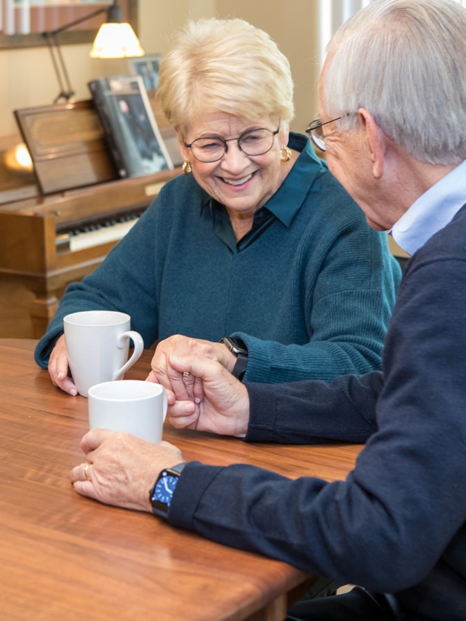 Elderly Couple Holding Hands At Table
