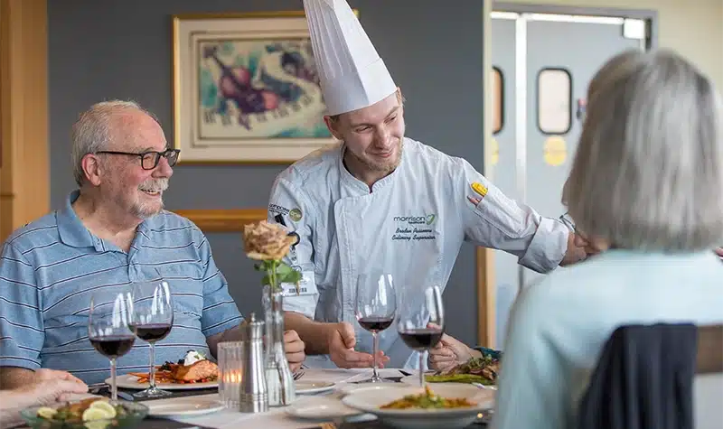Chef Standing Near Table Of Residents